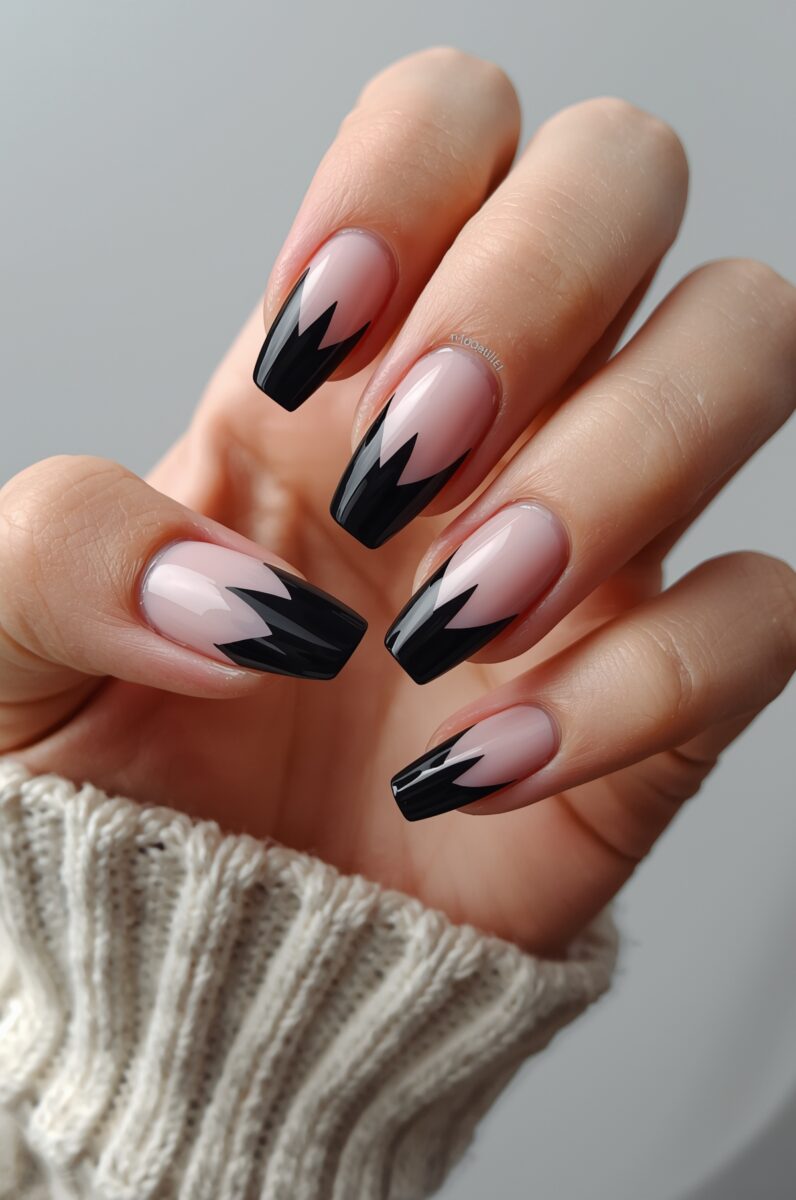 Hand with long square coffin nails featuring black geometric French tip design on nude pink base