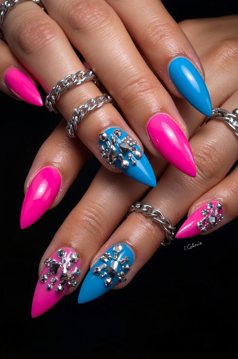 Stiletto acrylic nails in hot pink and blue with silver rhinestone snowflake nail art and chain rings