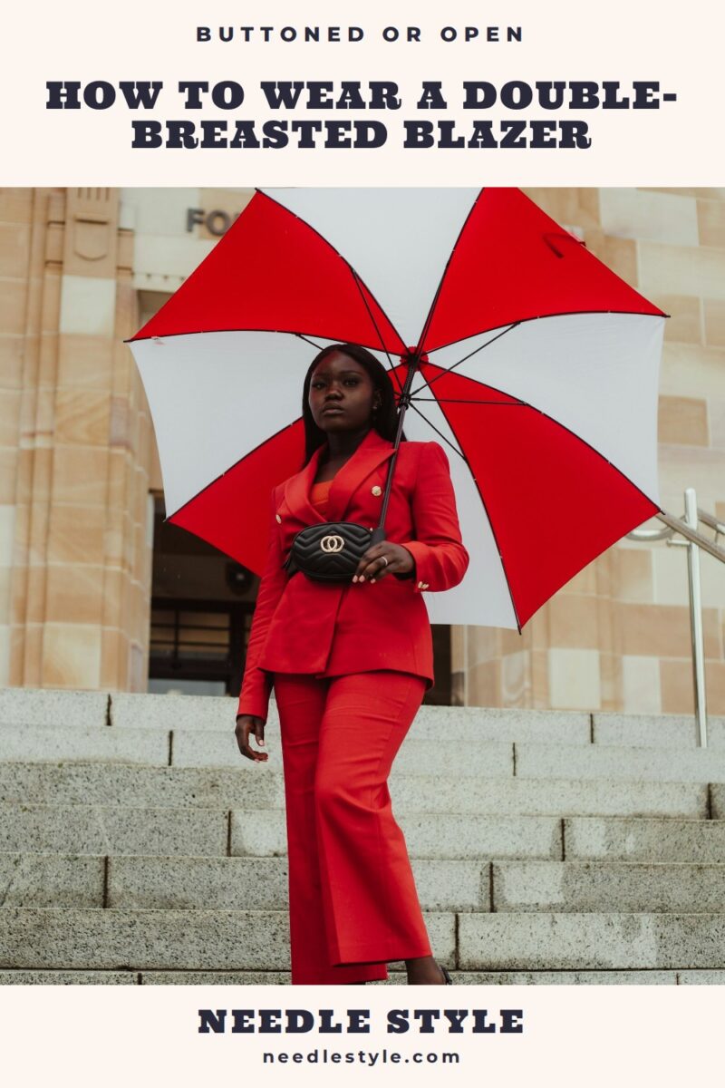 How to Wear a Double-Breasted Blazer: Woman in a red double-breasted suit with gold buttons and cropped wide-leg trousers, holding a red and white umbrella on stone steps