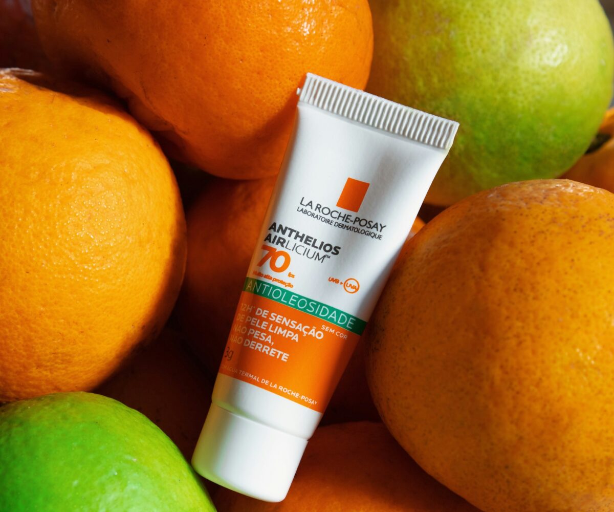 A tube of La Roche-Posay Anthelios SPF 70 face sunscreen lying on oranges and limes