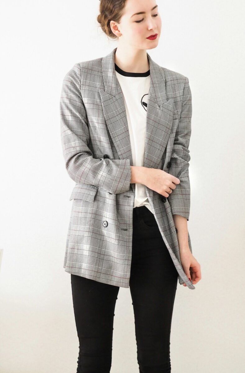 A gray check blazer, worn open over a white tee, with slim black pants