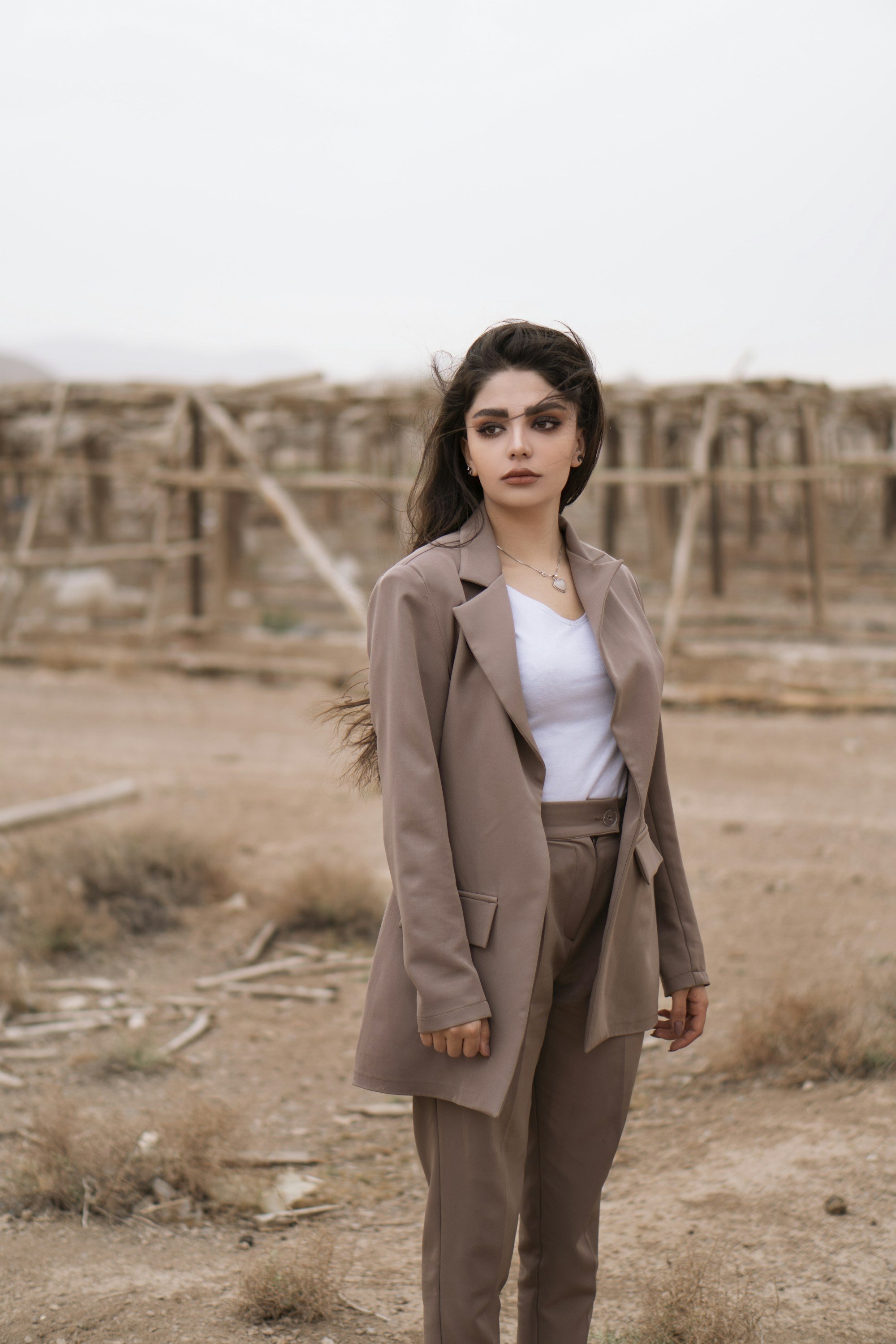 woman wearing a mocha blazer open over a white top and matching trousers